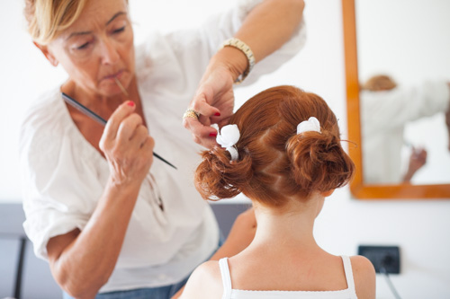 red hair little girl doing her her during her mom bridal preparation before a wedding day in ravenna italy