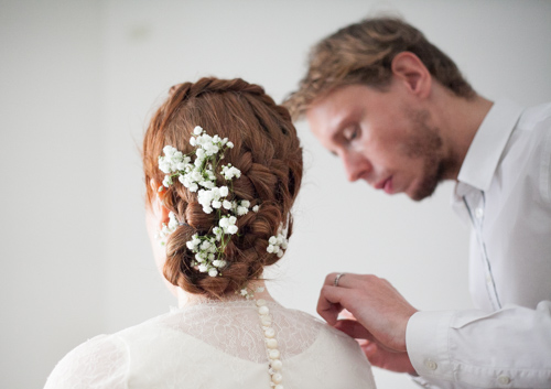 stylist fixing his bride's wedding dress during her bridal preparation in italy trento