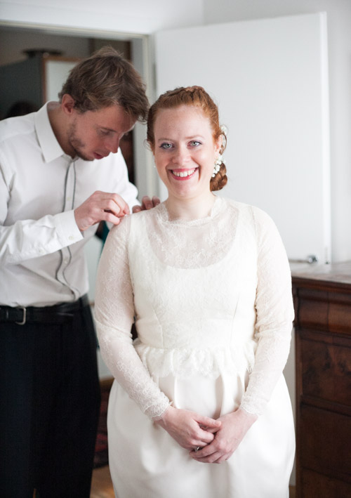 red hair bride getting ready and fixing her wedding dress in italy trento