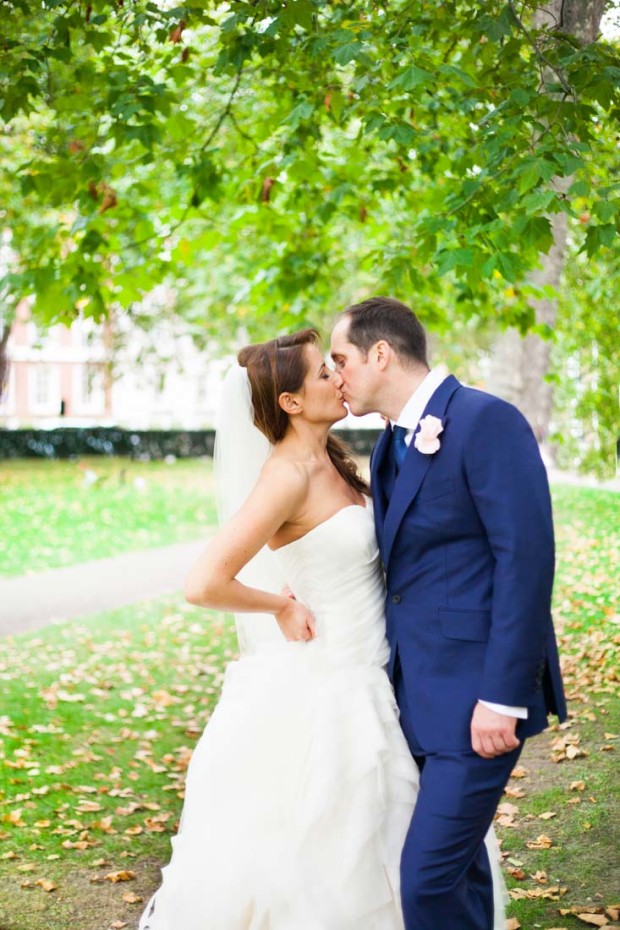 luxury couple kissing romantically under a tree in a park in mayfair london on their mayfair wedding