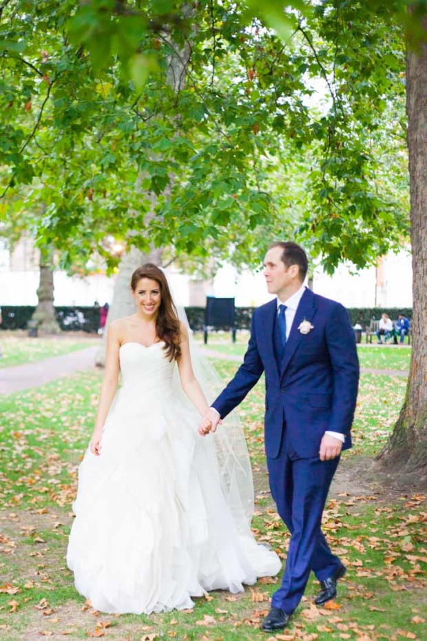 luxury bride and groom walking hand by hand in a park in mayfair london after their wedding