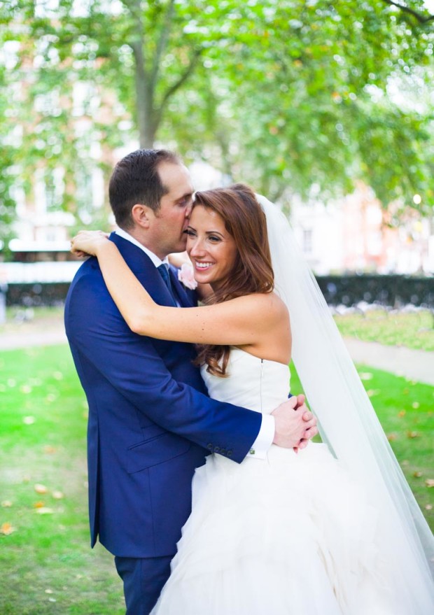 london couple kissing in a park in mayfair during their luxury wedding portraits