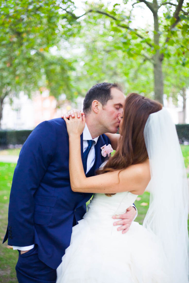 luxury wedding couple kissing in mayfair after their wedding ceremony wearing vera wang wedding gown