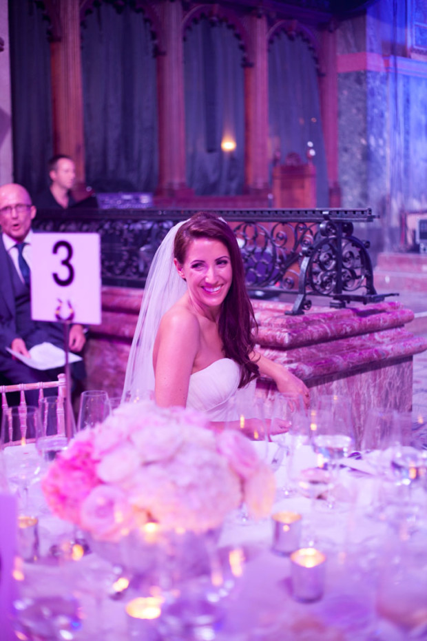 luxury bride sitting at her table at her wedding reception in one mayfair london with a pink light