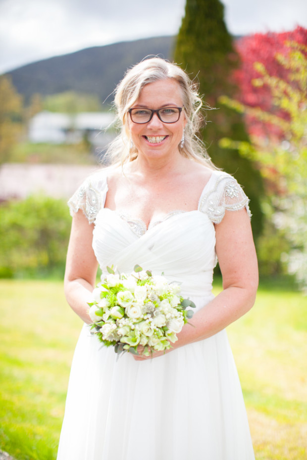 wedding portrait of a norwegian bride holding her wedding bouquet in her garden before the ceremony
