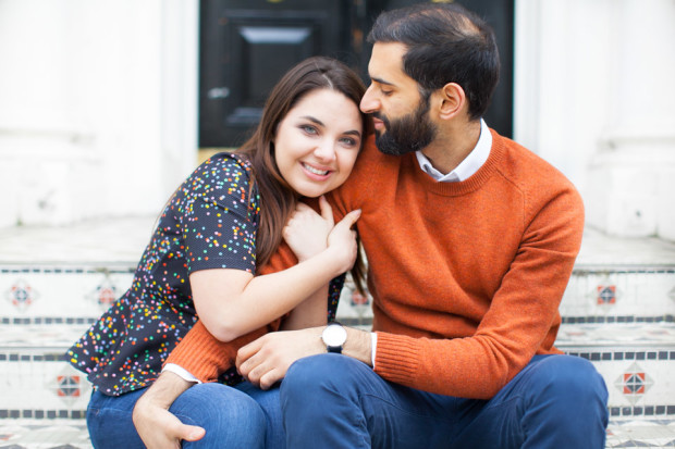 a couple cuddling on the footsteps of a house in holland park in london during their engagement session