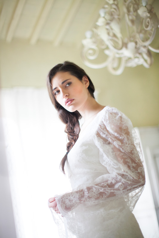 italian bride with a braid looking at herself in the mirror before her wedding day in italy