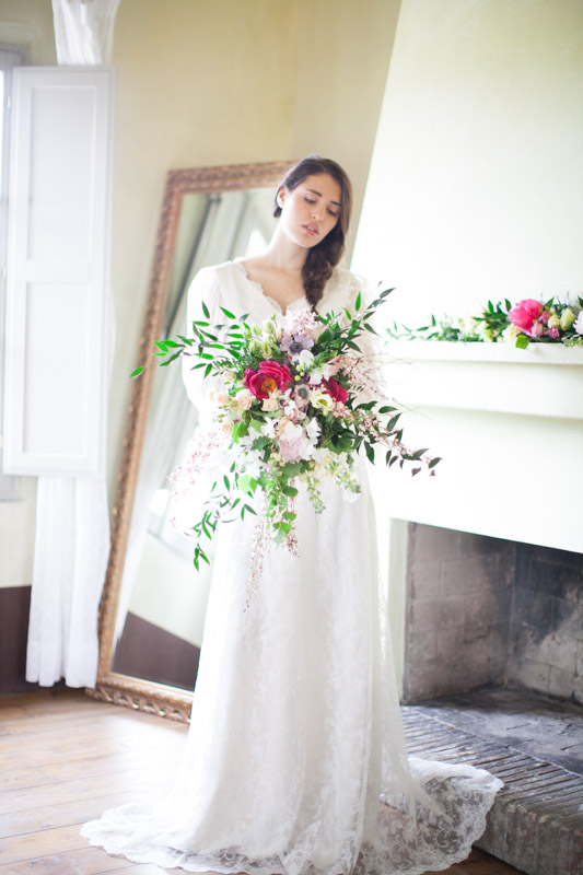 fine art wedding portrait of an italian bride during her getting ready before the wedding ceremony holding a deconstructed bouquet