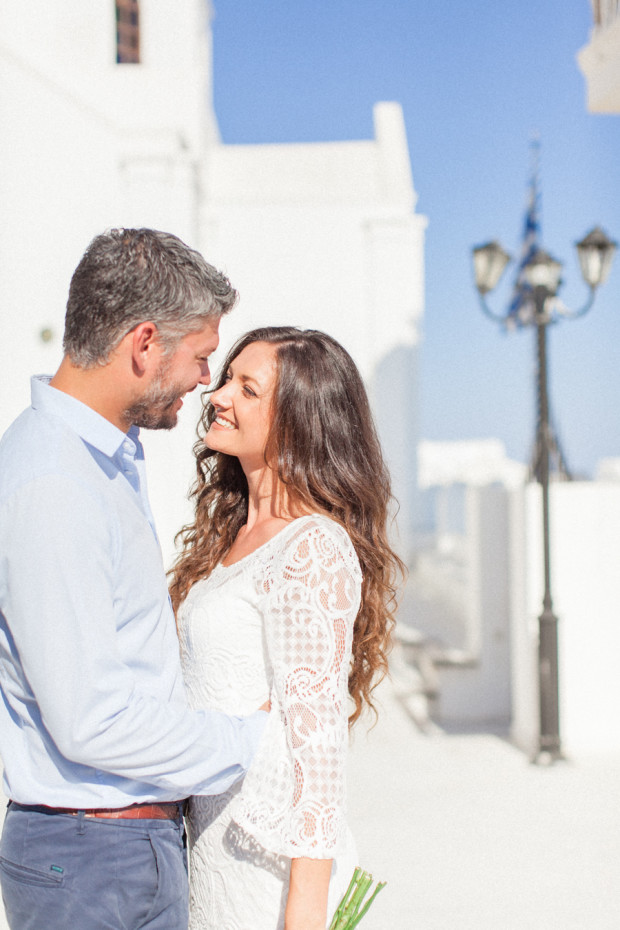 greek bride and groom smiling at each other and cuddling after their wedding in santorini greece