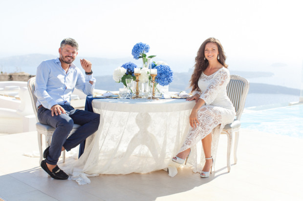 greek bride and groom sitting at their wedding table during a romantic and private pre wedding dinner at la maltese hotel in santorini greece
