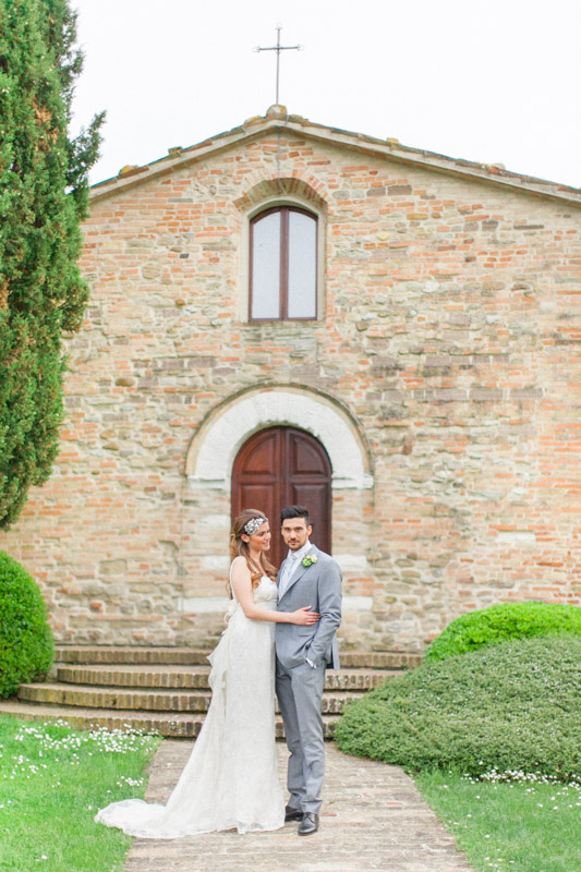 a bride and groom in italy outside the intimate church where they got married in italy at urbino resort
