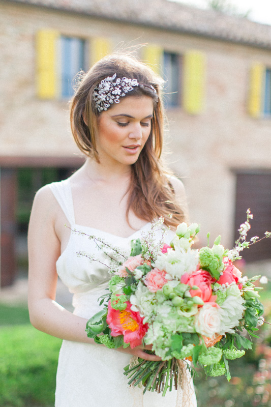 an italian bride holding her gorgeous wedding bouquet of peonies on her wedding day in may in italy