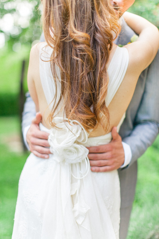 back of a wedding dress with silk flowers of a beautiful italian bride with long hair