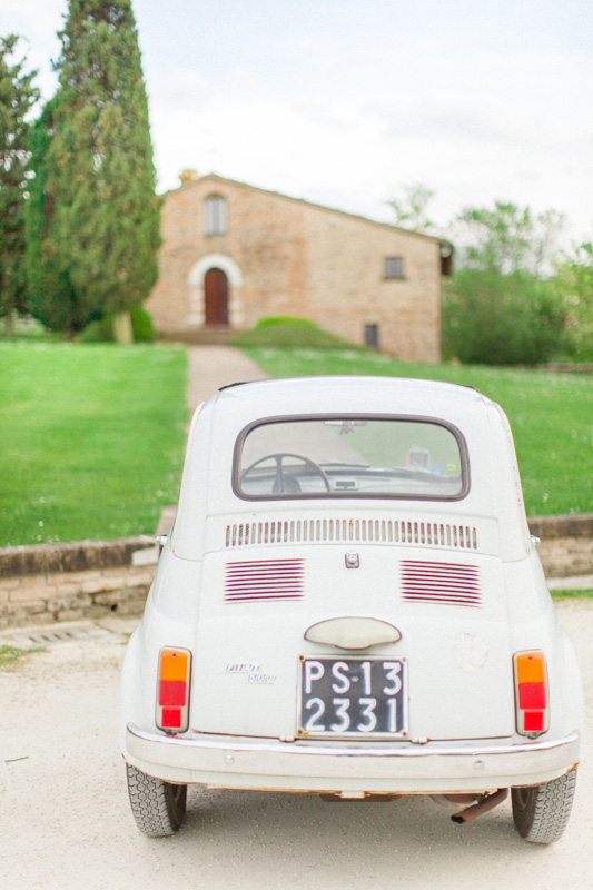 white fiat 500 in italy in the marche region in front of an intimate church