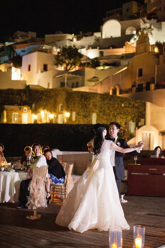 first dance at night under the stars between a chinese couple who just got married at their destination wedding in santorini at sun rocks hotel